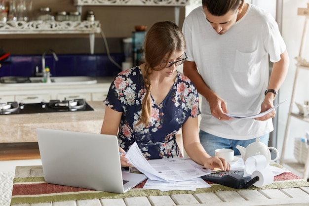 Couple managing budget together in kitchen