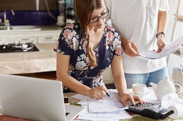 Free photo couple managing budget together in kitchen