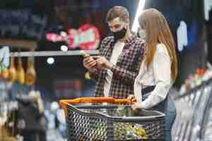 Free photo couple in medical protective mask in a supermarket.