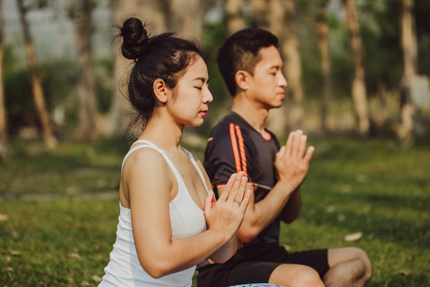 Couple meditating with praying hands