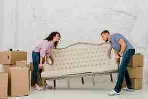 Free photo couple moving sofa