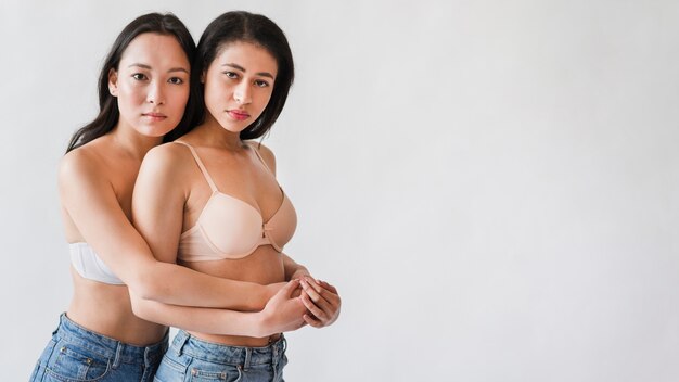 Couple of multiethnic women hugging in lingerie