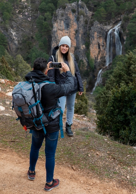 Пара на природе фотографирует с помощью мобильного телефона