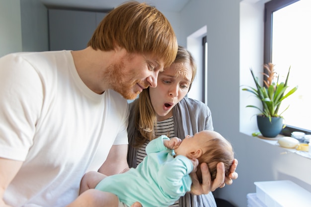 Couple of new parents enjoying cuddling daughter