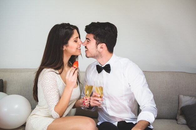 Couple nose with nose holding glasses of alcohol