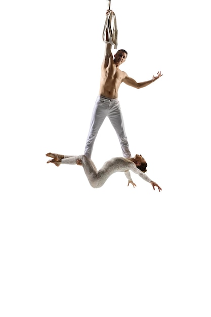 Бесплатное фото Пара молодых акробатов, спортсменов цирка, изолированных на белом.