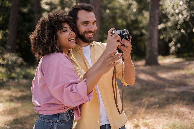 Couple outdoors taking pictures with camera