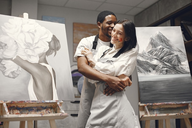 Couple in a painting class embracing.