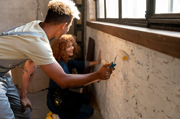 Couple painting their new home after moving in together