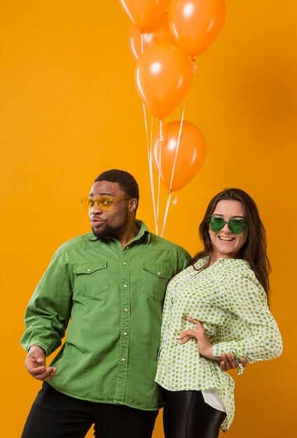 Couple at party having fun and holding balloons