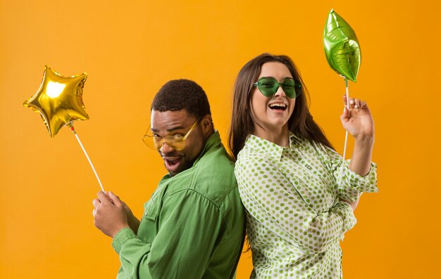 Couple at party having fun and holding balloons