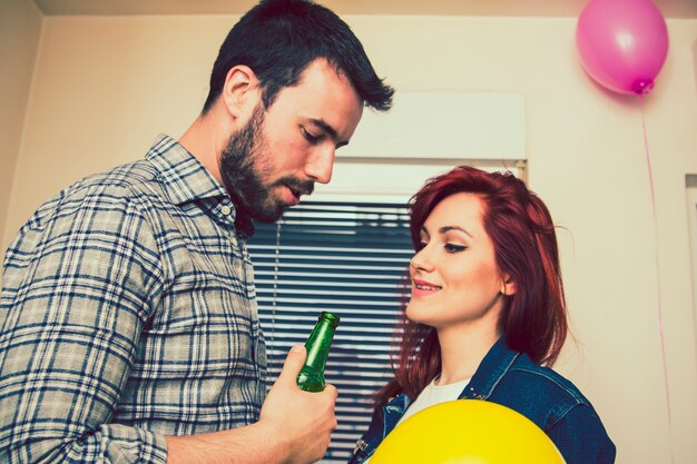 Foto gratuita coppia a festa con birra e palloncini