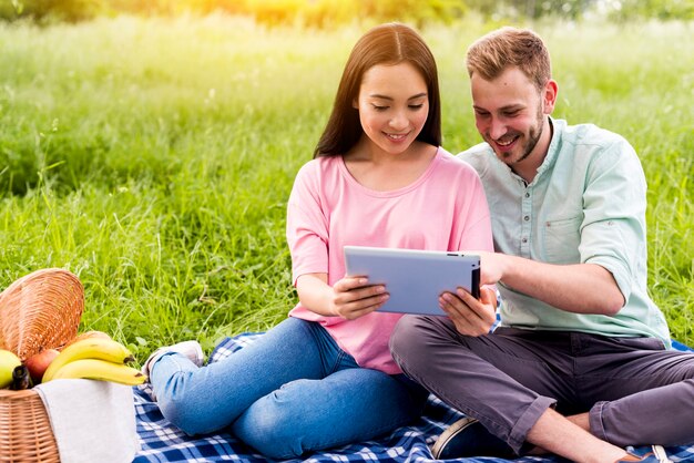 Couple on picnic using tablet