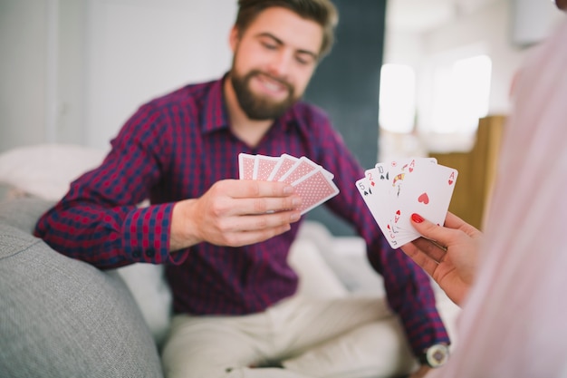Couple playing cards on sofa at home