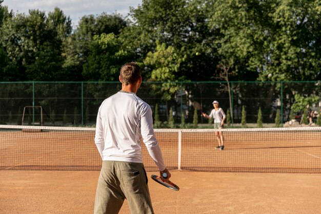 Пара играет в теннис друг против друга