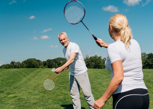 Пара играет в теннис вместе на открытом воздухе