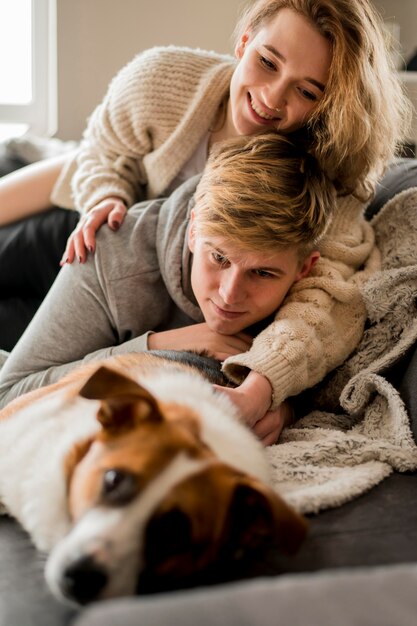 Couple playing with dog in bed