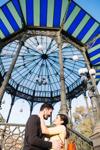 Couple posing in front of a pergola