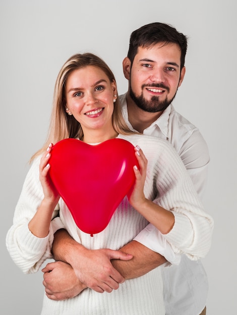 Couple posing and holding balloon