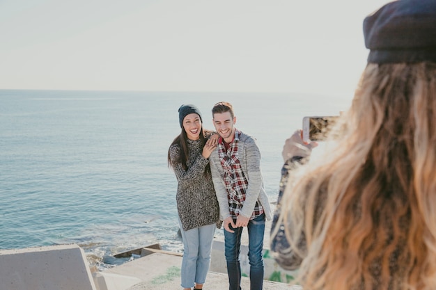 Couple posing for photo in front of sea