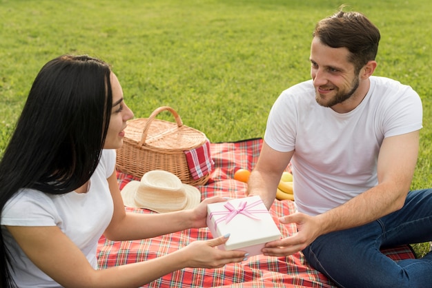 Coppie che posano su una coperta da picnic