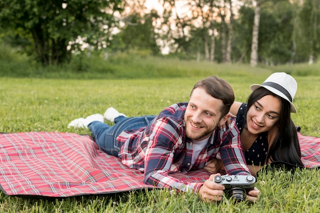 Coppie che posano su una coperta da picnic