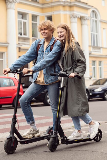 Couple posing together outdoors on electric scooters