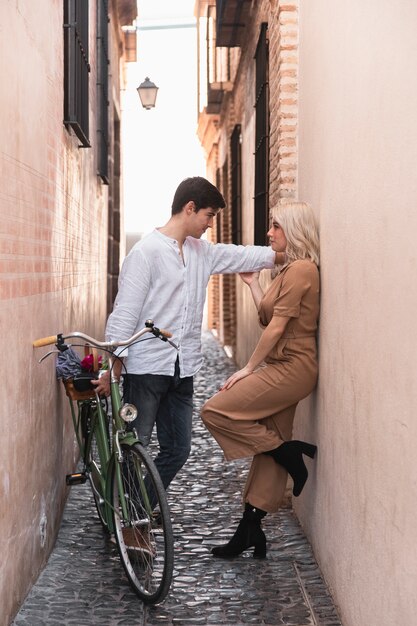 Couple posing with bicycle outdoors