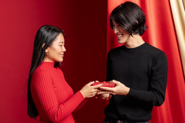Free photo couple posing with gift for chinese new year