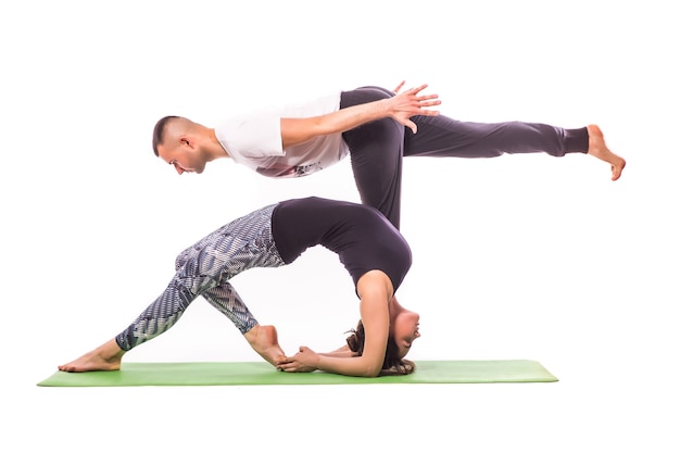 Couple practicing acro yoga in white studio. Acro yoga concept. Pair yoga. Yoga flexibility class workout