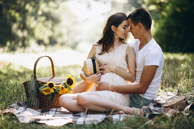 Couple pregnant, having picnic in park