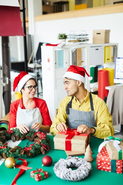 Couple preparing Christmas decoration and wrapping gifts