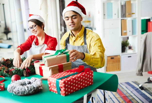 Foto gratuita coppia la preparazione di decorazioni natalizie e regali di confezionamento