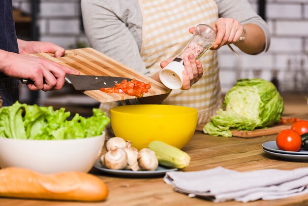 couple preparing vegetable salad