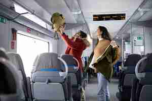 무료 사진 기차로 여행하는 동안 배낭을 치우고 재킷을 벗는 커플