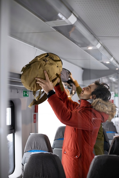 기차로 여행하는 동안 배낭을 치우는 커플