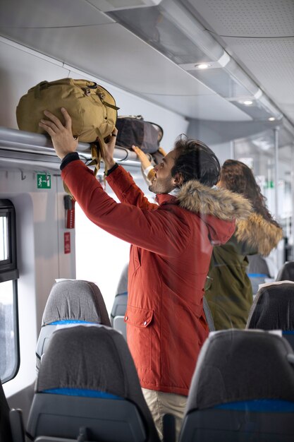 Couple putting their backpacks away while traveling by train