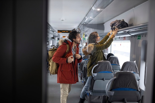 電車で旅行中にバックパックを片付けているカップル