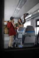 Free photo couple putting their backpacks away while traveling by train