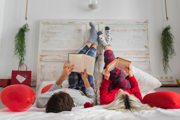 Free photo couple reading in bed on valentines day