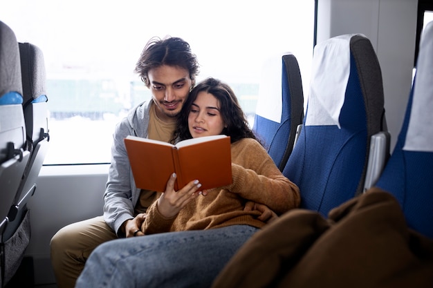 기차로 여행하는 동안 책을 읽는 커플