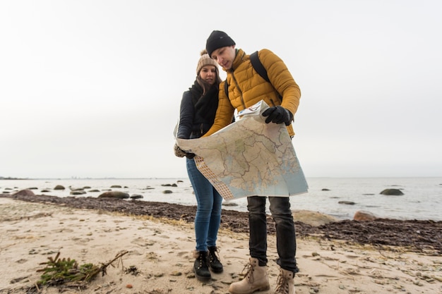 Пара, читающая карту на побережье