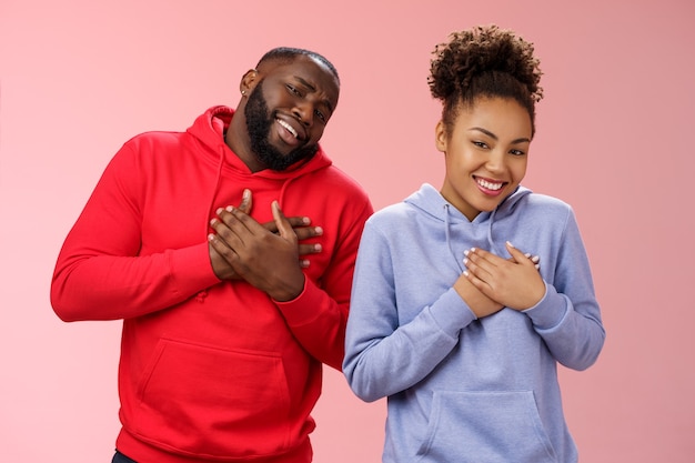 Couple receive compliments look good together. Portrait charming friendly loving african-american girlfriend boyfriend press palms heart touched pleased smiling broadly grateful moving words