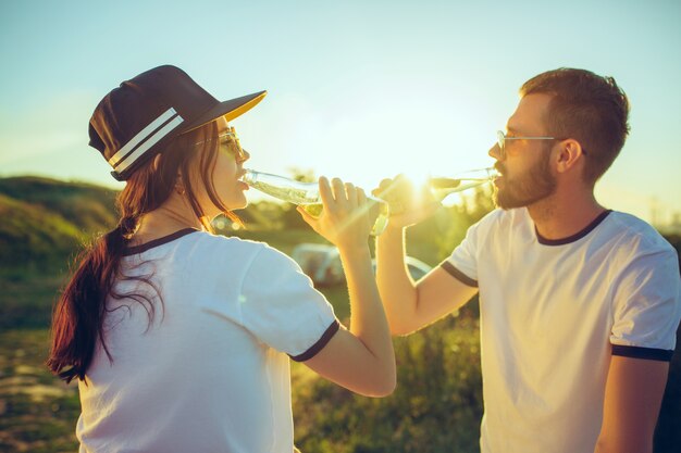 川の近くの夏の日にビーチで休んでいるカップル。愛、幸せな家族、休暇、旅行、夏のコンセプト。