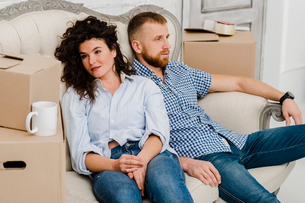 Couple resting near carton boxes