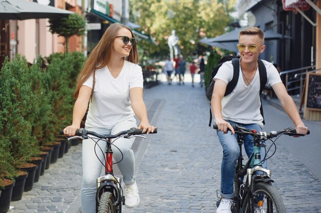 夏の街で自転車に乗るカップル