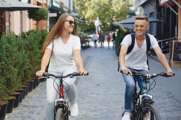 Couple riding bikes in summer city