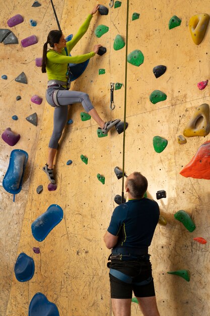 Couple rock climbing together indoors at the arena