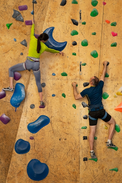 Free photo couple rock climbing together indoors at the arena