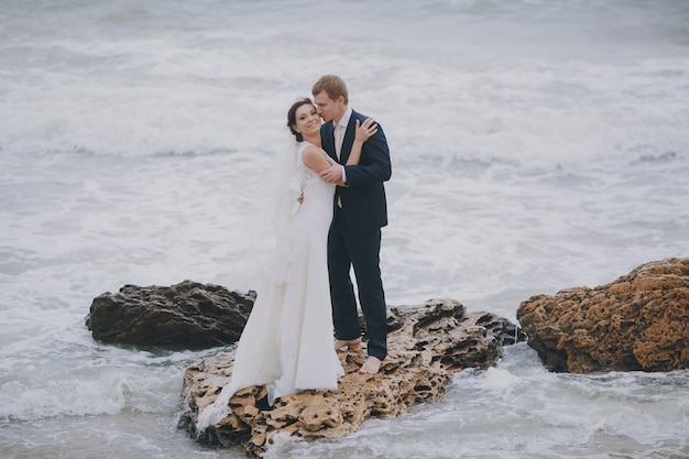 Free photo couple on a rock in the sea